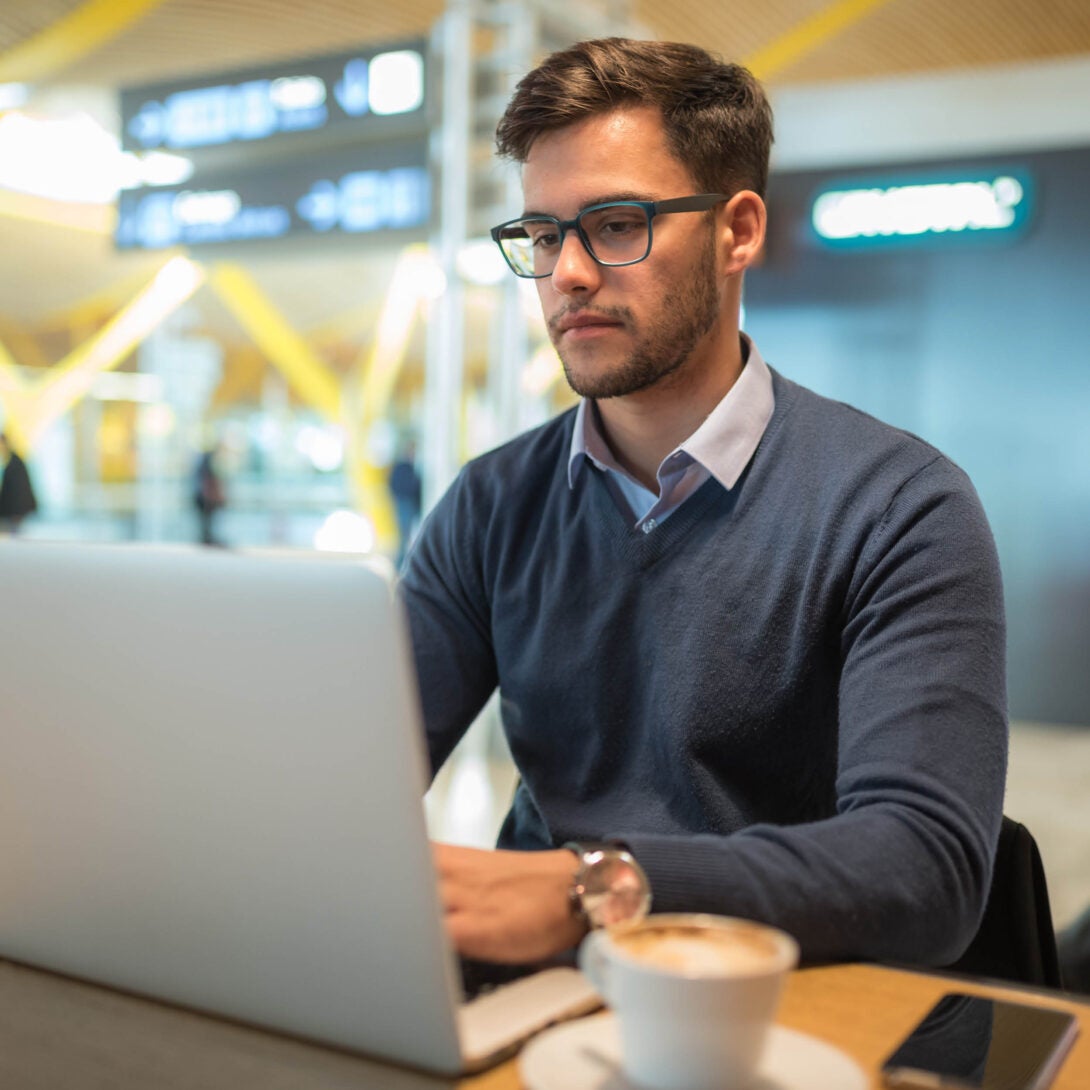 UIC student studying with glasses and coffee in front of laptop